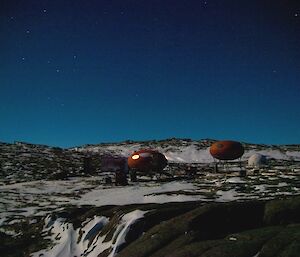 A nightime photo of the amarties and apple shelters on the island with stars shining in the sky