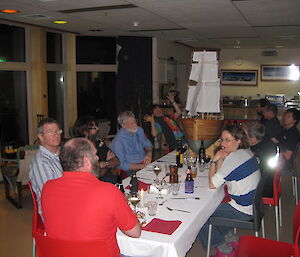 The dinner table adorned by a large wooden boat in the centre and expeditioners seated on chairs