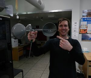 An expeditioner holding a new set of anemometer cups