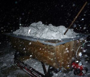 A mobile wooden hot tub full of snow in the evening before midwinter’s day