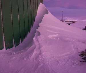 Beautifully sculptured snow on the downwind side of a large green Store building