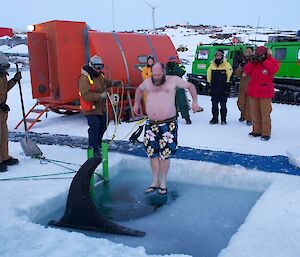 An expeditioner photographed in mid air before entering the water