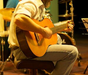 male expeditioner singing and playing guitar