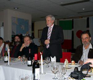 Five expeditioners. The station leader is standing and proposing a toast