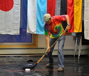 Female expeditioner lining up to hit the puck in ice hockey