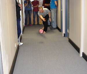 An expeditioner bowling in the corridor of the sleeping quarters
