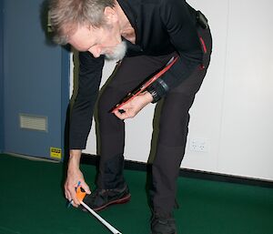 The Expeditioner judge measuring the distance of the bowl from the jack with a tape measure