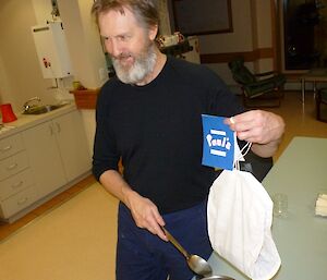 An expeditioner displaying his very large tea bag which was a gift from another expeditioner