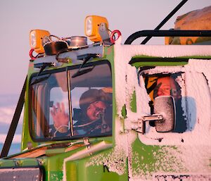 Two expeditioners in a green Hägglunds