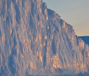 The surface of an iceberg glowing as the sun’s rays hit it