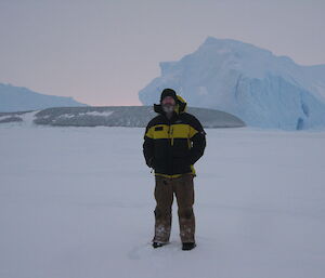 An expeditioner standing in front of several icebergs including a bottle green Jade Berg