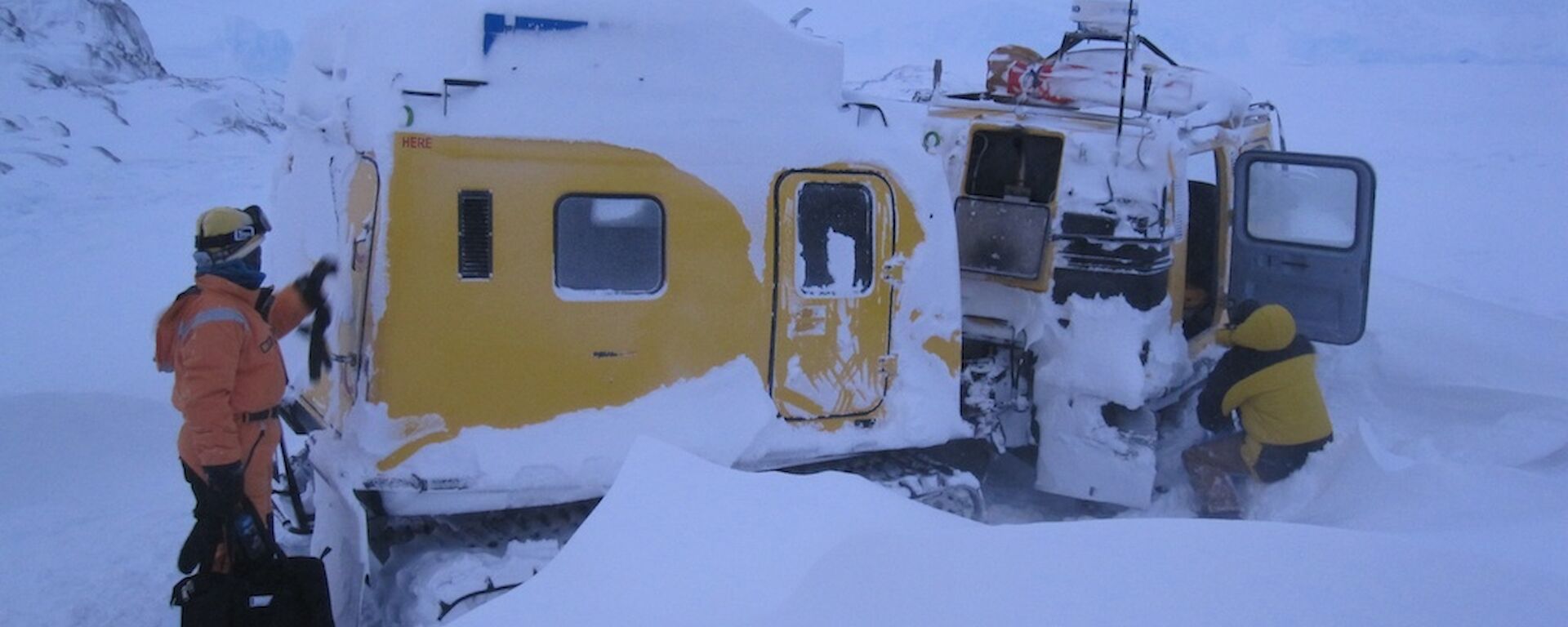 Oversnow vehicle with snow covering the roof and sides