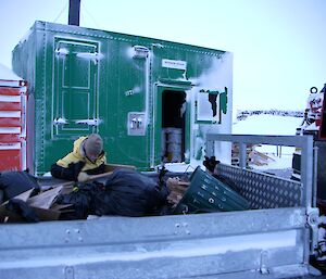 An expeditioner unloading garbage from the tray of the Hägglunds with the incinerator behind