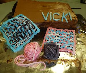 A close up of the balls of wool and crocheted squares on the female expeditioner’s half of the cake