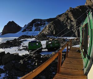 View of the side of a hut with mountains in the distance