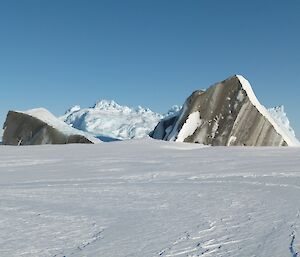 An iceberg which has scarped across the moraine and toppled over exposing a surface with rocks and dirt