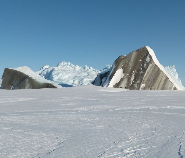 An iceberg which has scarped across the moraine and toppled over exposing a surface with rocks and dirt