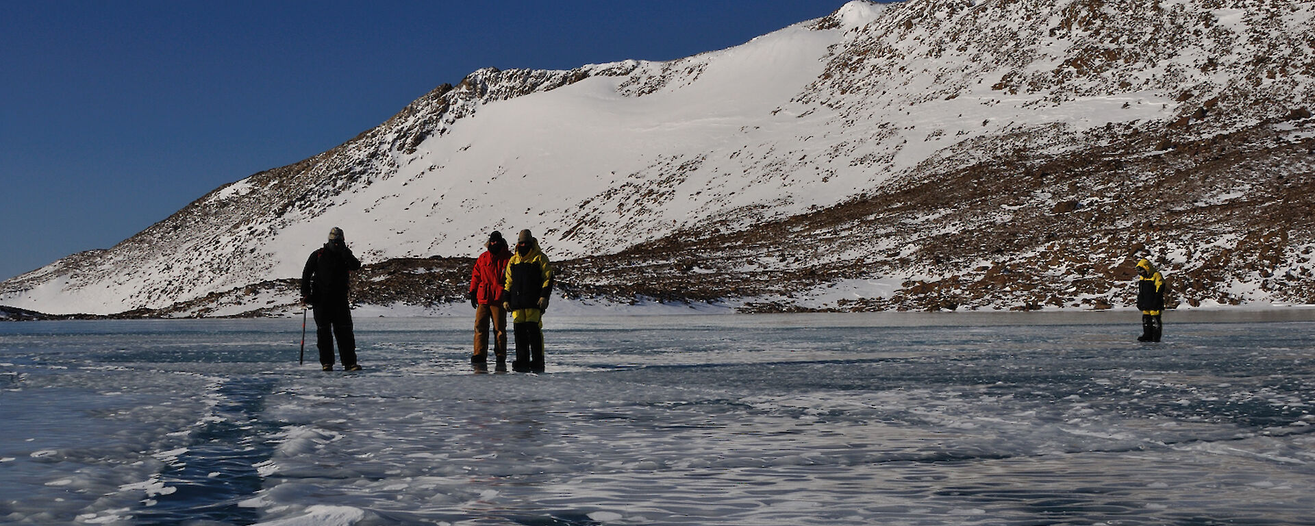 Expeditioners standing on frozen lake