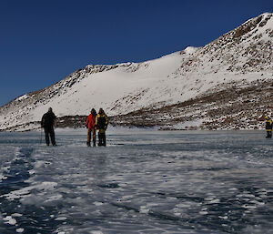 Expeditioners standing on frozen lake