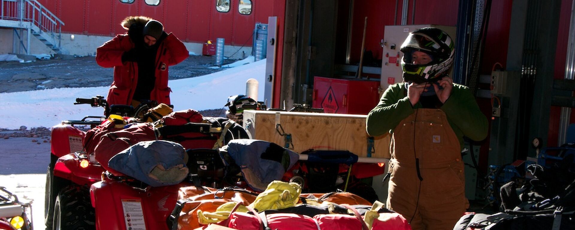 Expeditioners putting on helmets and protective gear prior to riding the quad bikes