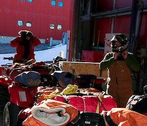 Expeditioners putting on helmets and protective gear prior to riding the quad bikes