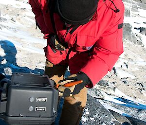 Expeditioner removing snow from protective cap using a soft bristle brush