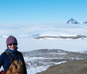 Expeditioner on top of Welch Island with Mt Henderson and Onley Hill in the background