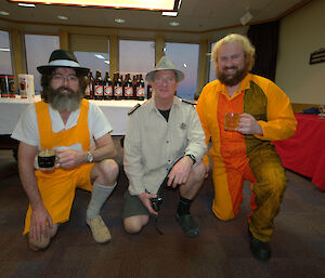 Three people dressed up with beers in their hands