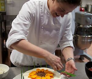 Chef putting the finishing touches to cake decorations