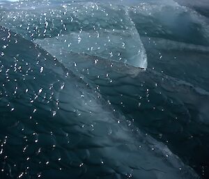 The glistening green surface of a jade iceberg