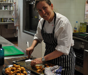 An expeditioner plating the sausage rolls as one of the hors d'oeuvres to accompany the champagne