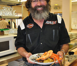 An expeditioner obviously happy with his meal of seafood