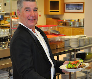 An expeditioner with his meal of beef fillet and Mawson salad