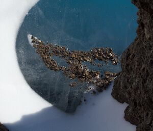 Detail of fine gravel collecting on a frozen lake surface