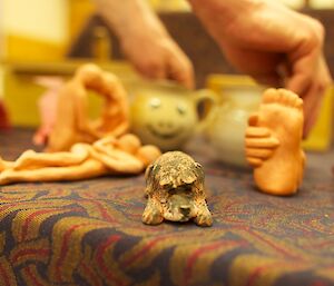 A close up of of ceramic gifts depicting love, foot massage and a dog