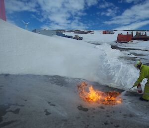 An expeditioner getting down low to extinguish the simulated fuel fire