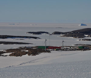A view looking down onto mawson from the ice plateau with the islands and frozen sea ice stretching out to the horizon