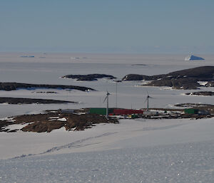A view looking down onto mawson from the ice plateau with the islands and frozen sea ice stretching out to the horizon
