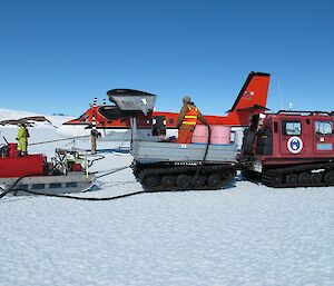 Refuelling the plane with drums of ATK on the tray of the Hägglunds with the aviation pump on the sledge