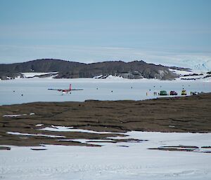 A photo from station across Horseshoe Harbour with a Twin Otter and several vehicles on the sea ice
