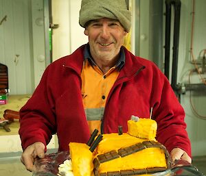 An expeditioner holding his birthday made in teh shape of a D7 dozer