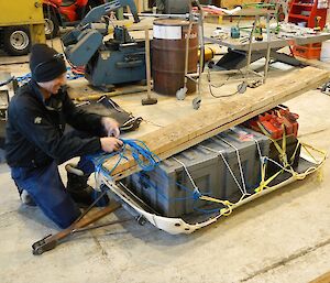 Kelvin ties the gear and the ramps onto the sled