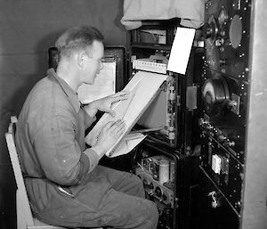 Weather Observer Bob Dingle sitting at the radiosonde recorder on Macquarie Island, 1956.