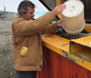 Man emptying rubbish into skip