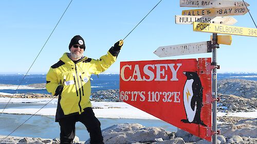 Speculative fiction author Sean Williams beside the Casey station sign.