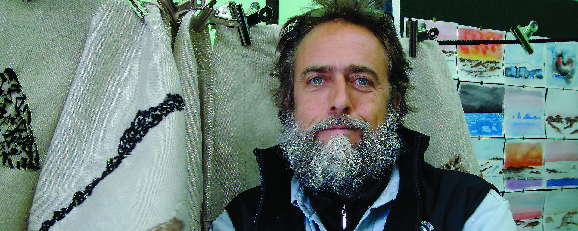 Artist Stephen Eastaugh in his studio with Antarctic prints.