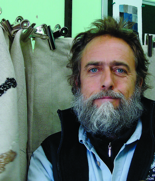Artist Stephen Eastaugh in his studio with Antarctic prints.