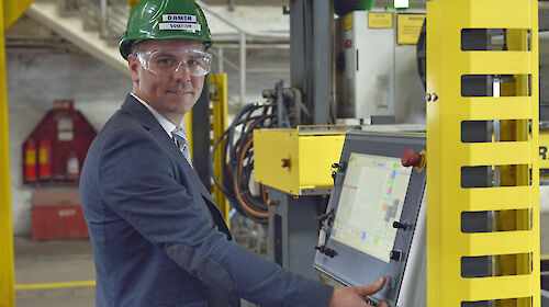 Man in hard hat about to hit button on panel