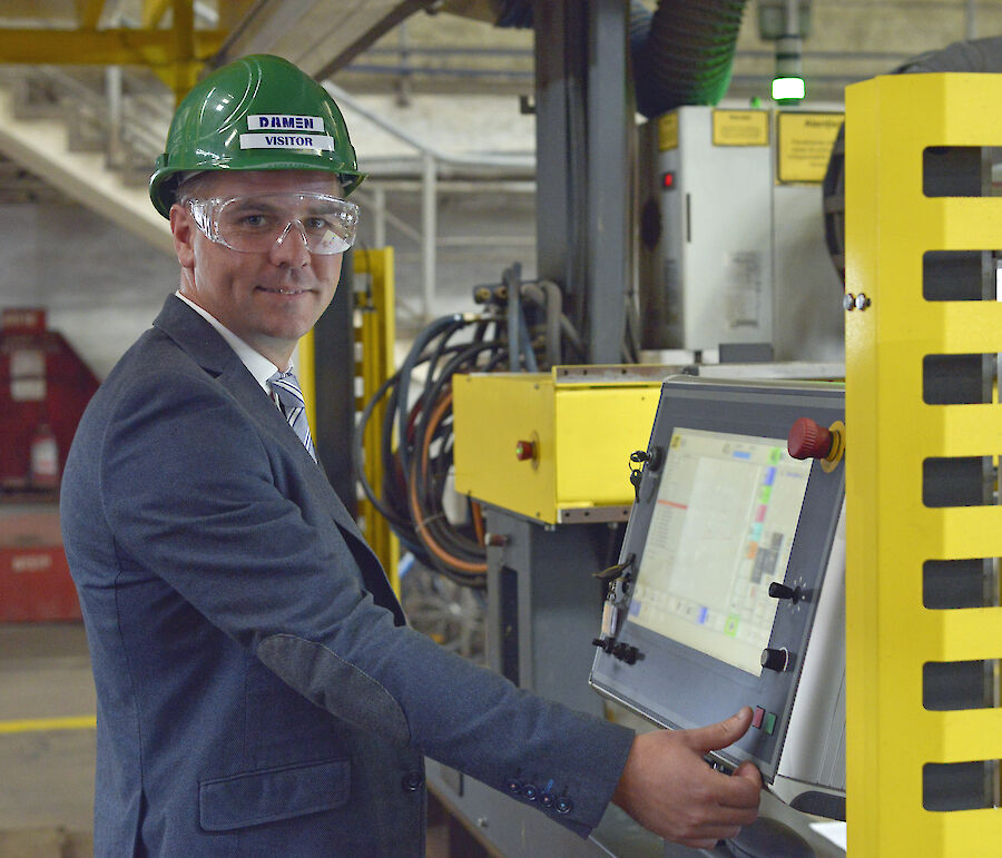 Man in hard hat about to hit button on panel