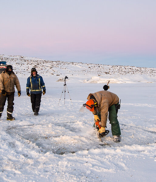 Chainsawing hole in ice